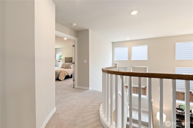 corridor featuring baseboards, carpet, recessed lighting, and an upstairs landing