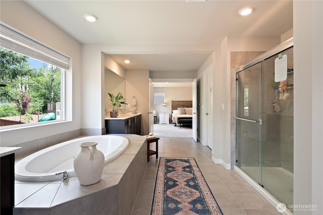 bathroom with tile patterned flooring, vanity, a shower stall, ensuite bathroom, and a garden tub