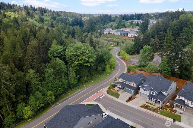birds eye view of property featuring a wooded view and a residential view