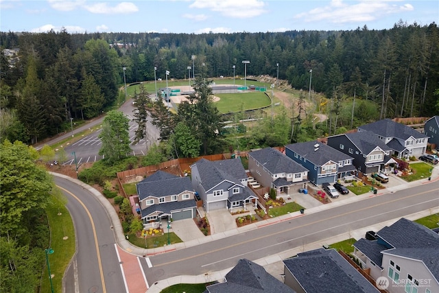 drone / aerial view featuring a residential view and a forest view