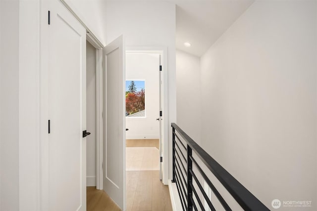 corridor featuring recessed lighting, baseboards, and light wood-type flooring