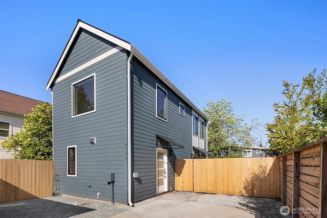 rear view of house featuring a fenced backyard and a patio