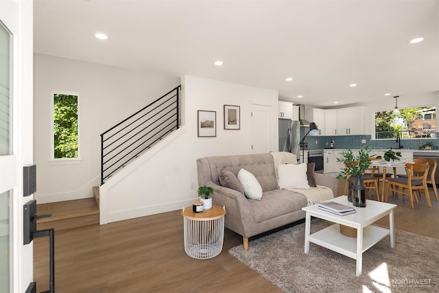 living area featuring baseboards, recessed lighting, and stairs