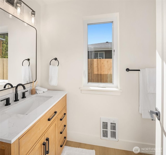 bathroom with visible vents, baseboards, plenty of natural light, and vanity