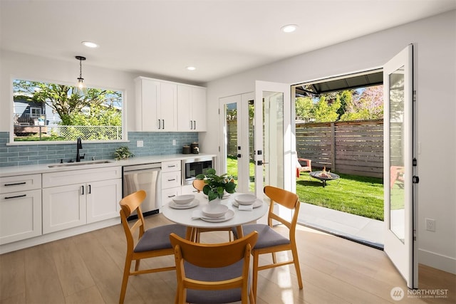 kitchen featuring light countertops, a sink, light wood-type flooring, and stainless steel appliances