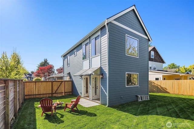 rear view of property with a lawn and a fenced backyard