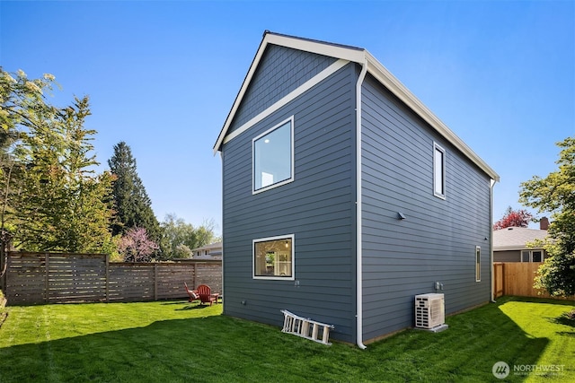 back of house with a yard and a fenced backyard