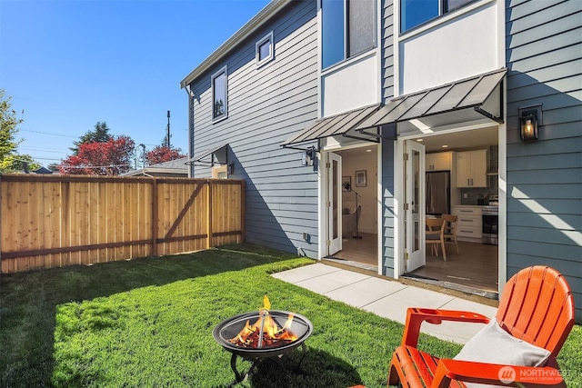 view of yard featuring fence and an outdoor fire pit