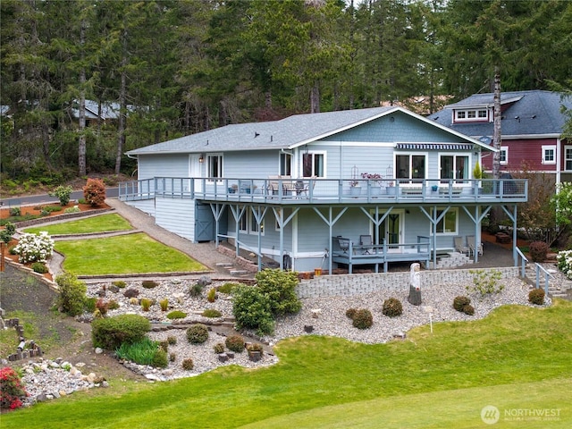 rear view of house with a lawn and a wooden deck