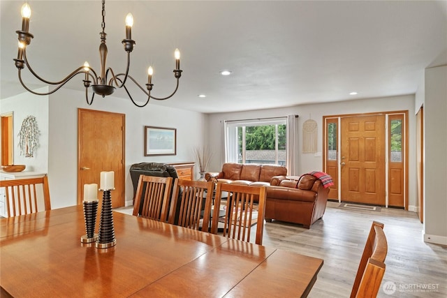 dining space with recessed lighting, an inviting chandelier, and light wood-style flooring