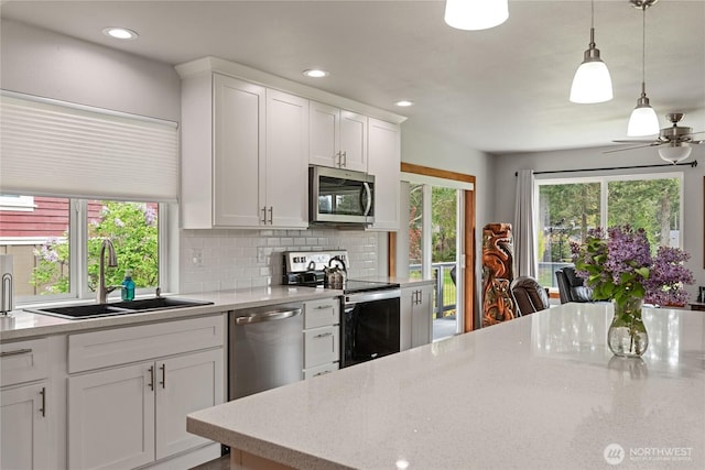 kitchen featuring a sink, white cabinets, backsplash, and stainless steel appliances