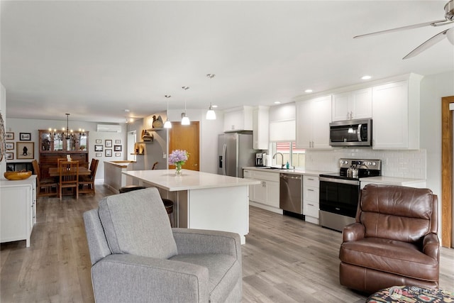 kitchen with appliances with stainless steel finishes, white cabinets, and open floor plan
