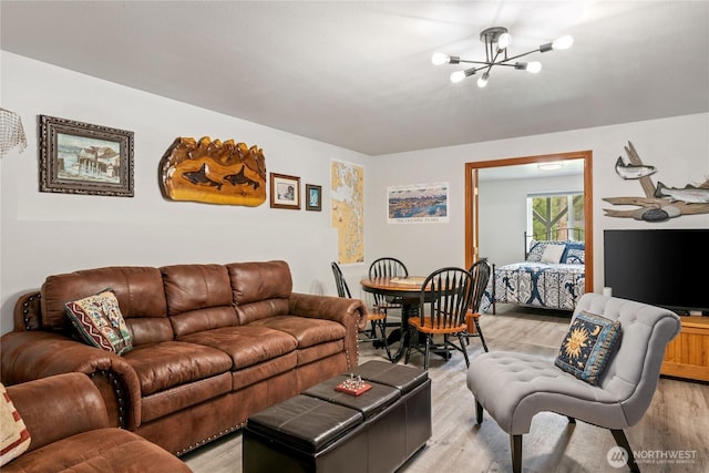 living area with a notable chandelier and light wood-style floors