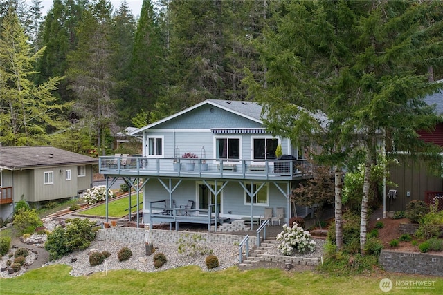 rear view of house with a deck and a forest view