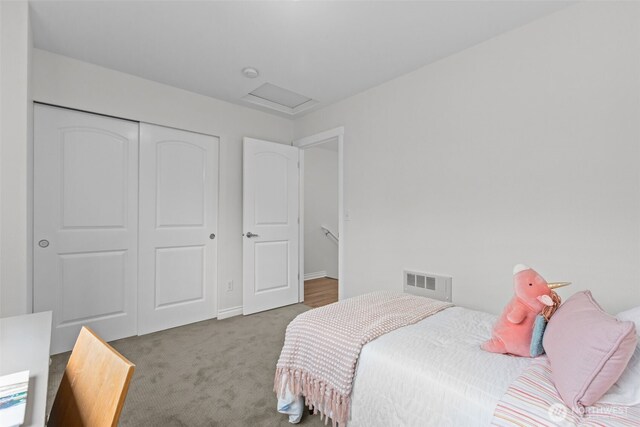 carpeted bedroom with visible vents, attic access, and a closet