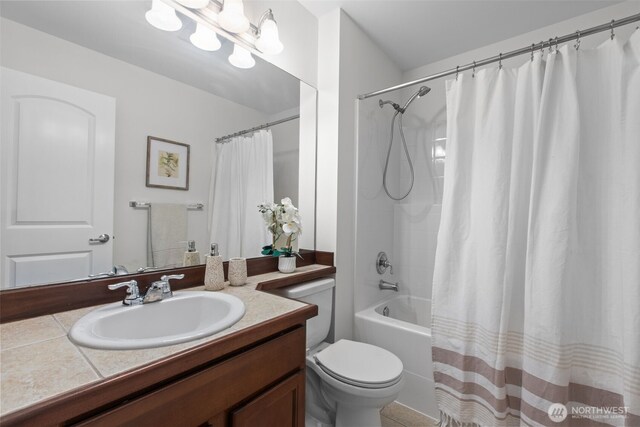 bathroom with vanity, shower / bath combination with curtain, and toilet