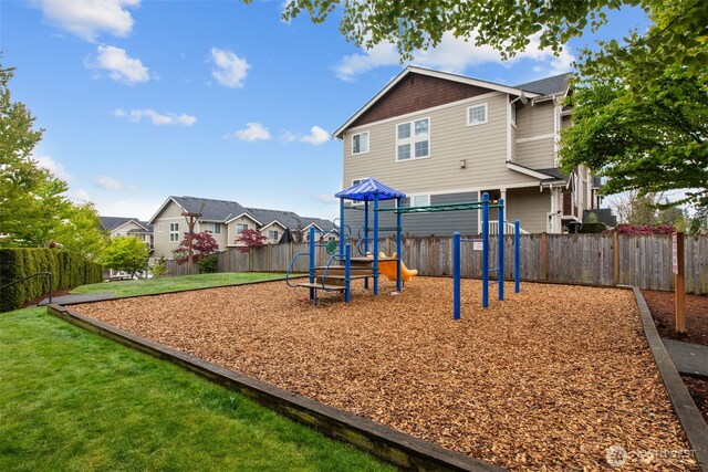 view of jungle gym with a fenced backyard, a lawn, and a residential view