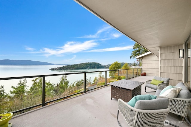 balcony with an outdoor hangout area and a water view