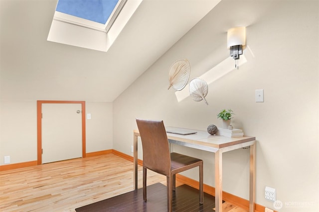 office space featuring baseboards, lofted ceiling with skylight, and wood finished floors