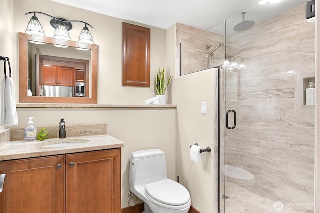 full bath featuring vanity, toilet, and a shower stall