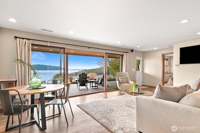living room with recessed lighting, baseboards, visible vents, and wood finished floors