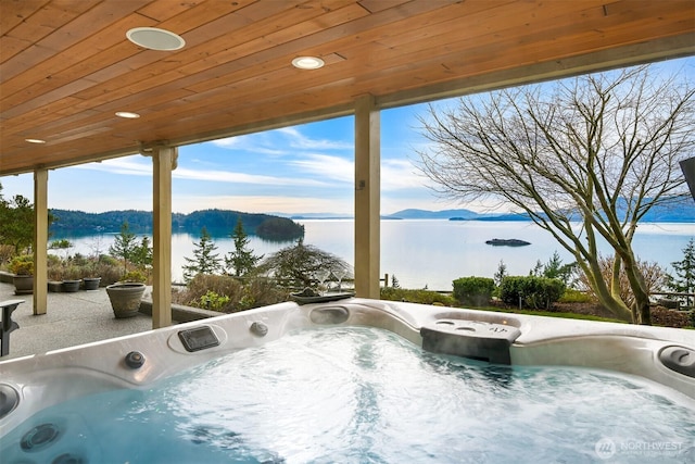 exterior space featuring a water view and a hot tub