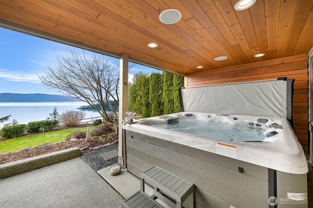 view of patio / terrace featuring a hot tub and a water view