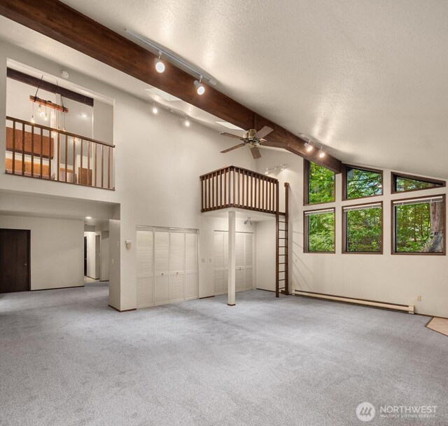 unfurnished living room with a ceiling fan, a baseboard heating unit, rail lighting, and carpet flooring
