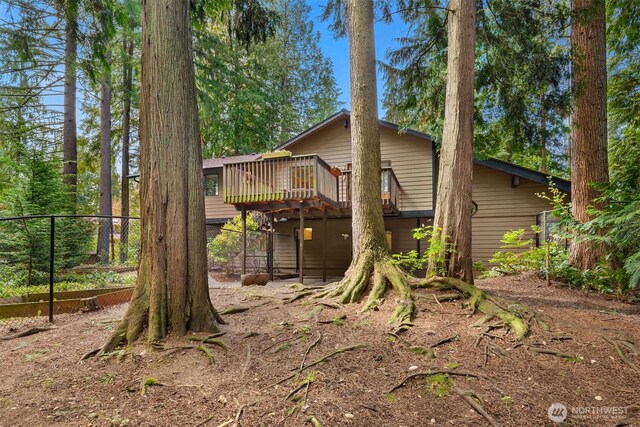 view of property exterior featuring fence and a wooden deck