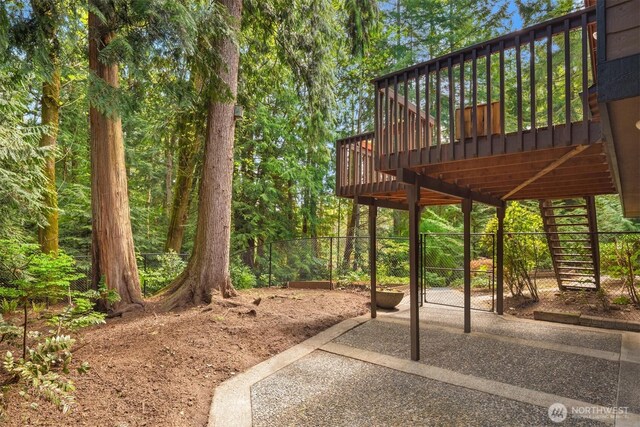 view of yard with fence, a wooden deck, and stairway