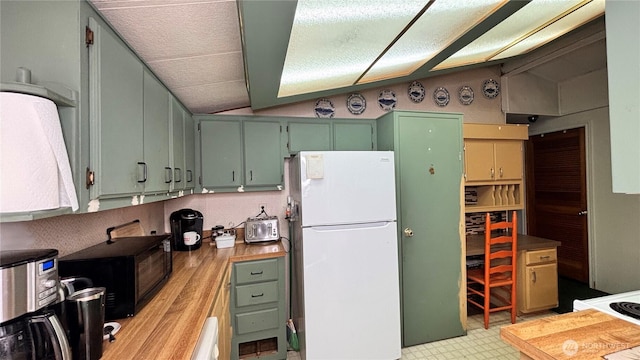 13118 Lost Lake Rd Unit 12, Snohomish, WA 98296 - kitchen featuring freestanding refrigerator, black microwave, vaulted ceiling, light floors, and green cabinets
