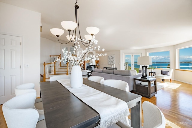 8012 Chinook Way, Blaine, WA 98230 - dining space featuring light wood-style floors, a water view, stairs, and a chandelier