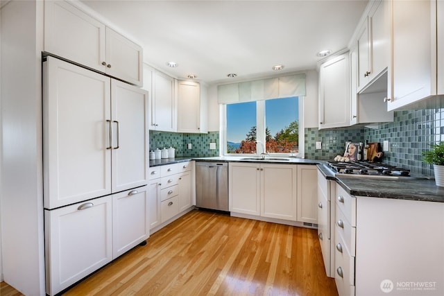 8012 Chinook Way, Blaine, WA 98230 - kitchen featuring white cabinets, a sink, stainless steel appliances, light wood-type flooring, and backsplash