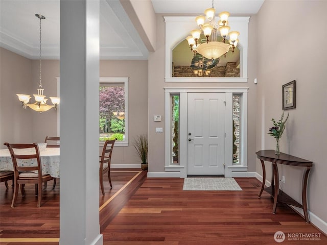 entryway with an inviting chandelier, baseboards, and wood finished floors