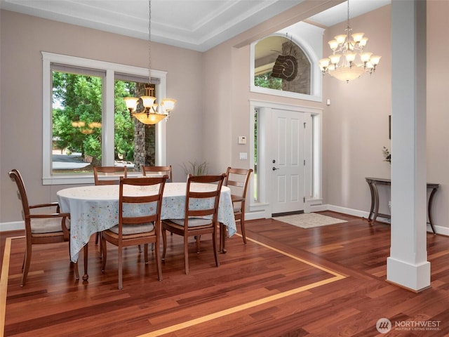 dining space featuring an inviting chandelier, baseboards, and wood finished floors