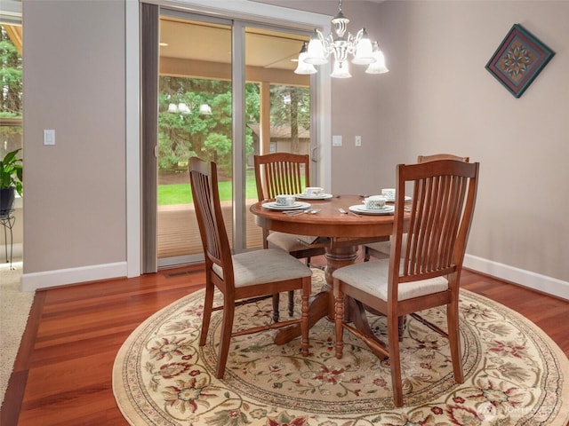 dining room with baseboards, wood finished floors, and a chandelier