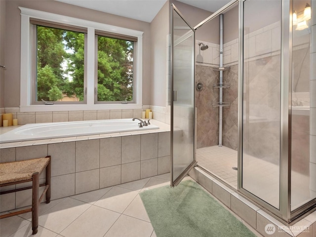 full bathroom featuring tile patterned flooring, a bath, and a stall shower