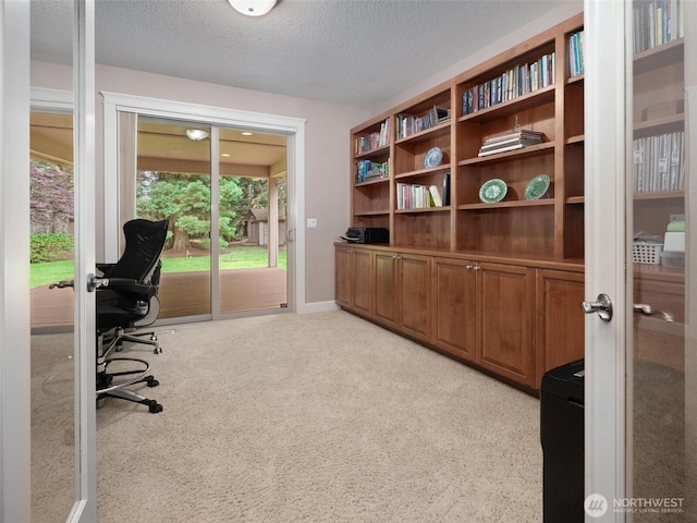 office area featuring french doors, a textured ceiling, and light colored carpet