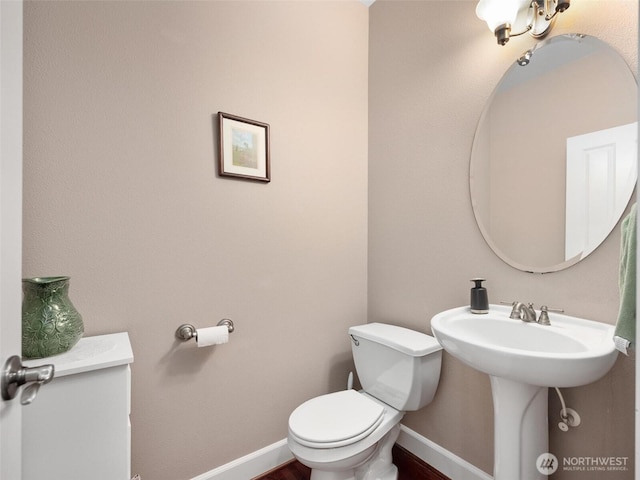 bathroom with baseboards and toilet