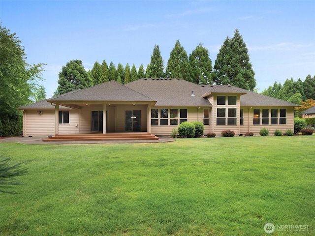 rear view of house with a yard, crawl space, a wooden deck, and roof with shingles