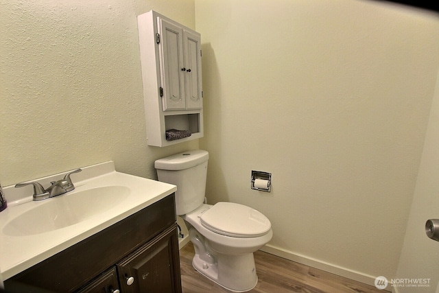 3425 S 176th St Unit 227, Seatac, WA 98188 - bathroom with toilet, baseboards, wood finished floors, and vanity