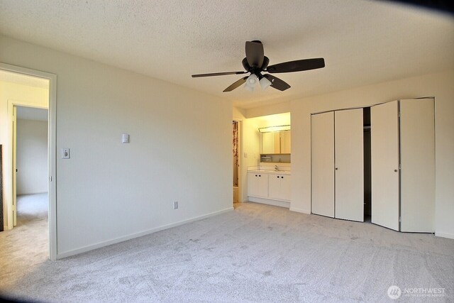 3425 S 176th St Unit 227, Seatac, WA 98188 - unfurnished bedroom featuring baseboards, a ceiling fan, ensuite bath, and light carpet