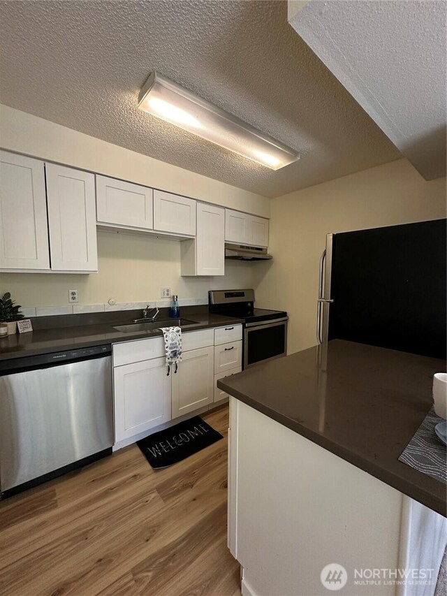 3425 S 176th St Unit 227, Seatac, WA 98188 - kitchen featuring a textured ceiling, light wood-type flooring, stainless steel appliances, and a sink