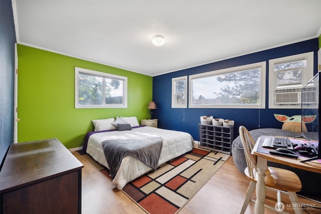 bedroom with ornamental molding and light wood-type flooring