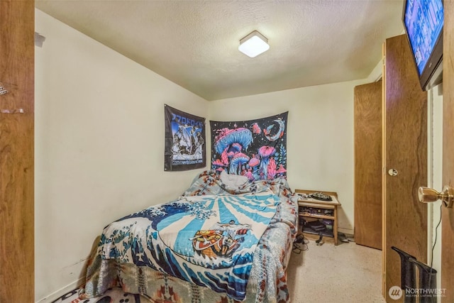 bedroom with a textured ceiling and baseboards