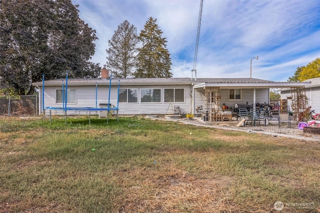 rear view of property with a lawn, a patio, fence, and a chimney