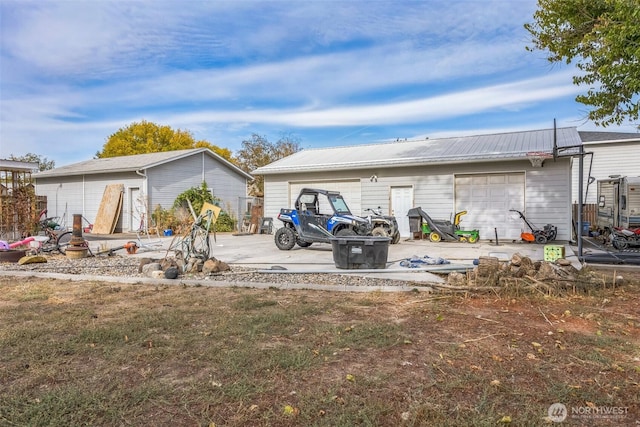 rear view of property with metal roof and an outdoor structure