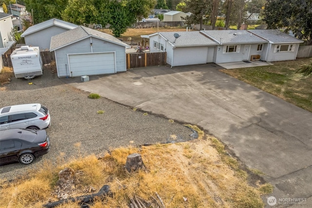 ranch-style house with a garage and fence