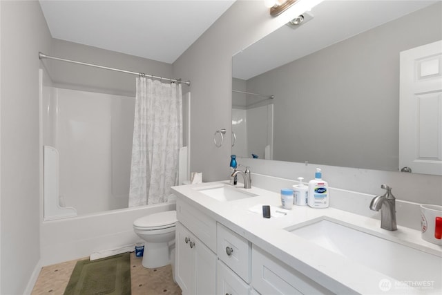 full bath with double vanity, a sink, shower / bath combo, and toilet