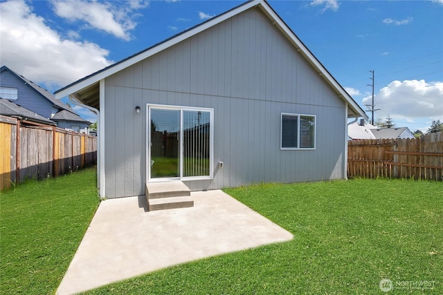 back of house with a yard, a fenced backyard, and a patio area